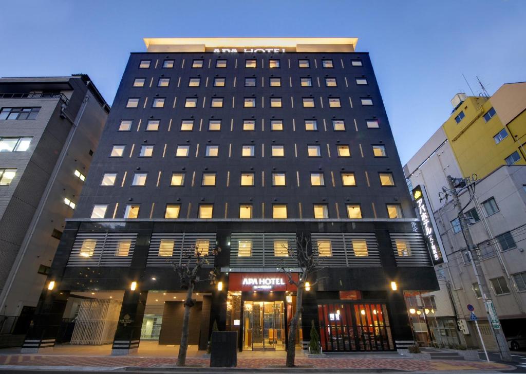 a large building with a clock on the front of it at APA Hotel Hatchobori-eki Minami in Tokyo