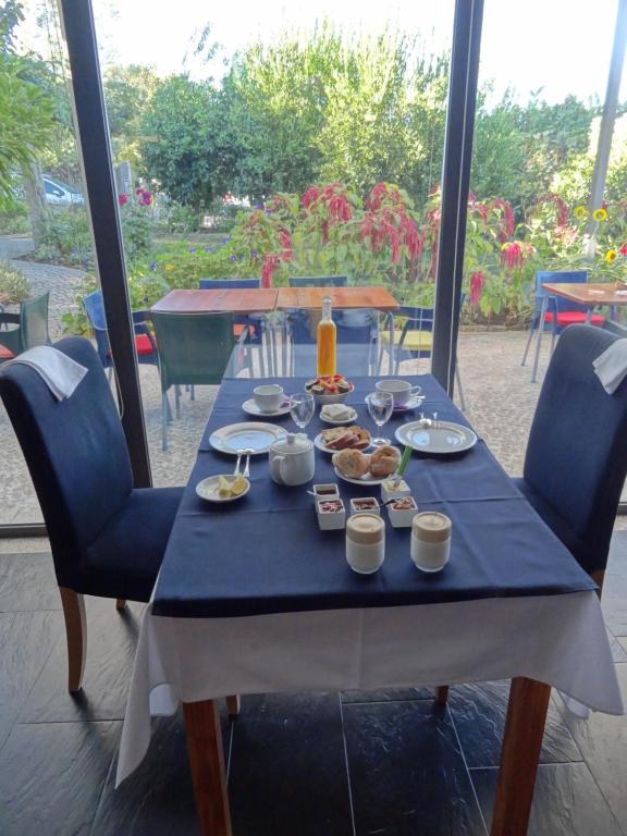 una mesa azul con platos de comida. en Quinta das Delicias, en São Tiaguinho