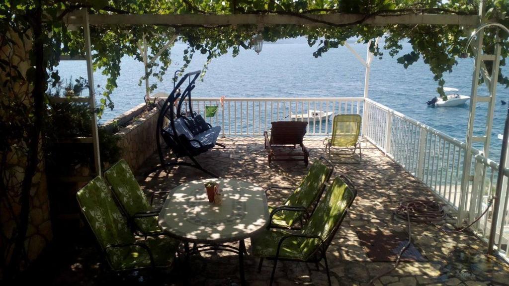 a patio with a table and chairs and the water at Apartment Bonaca in Komarna