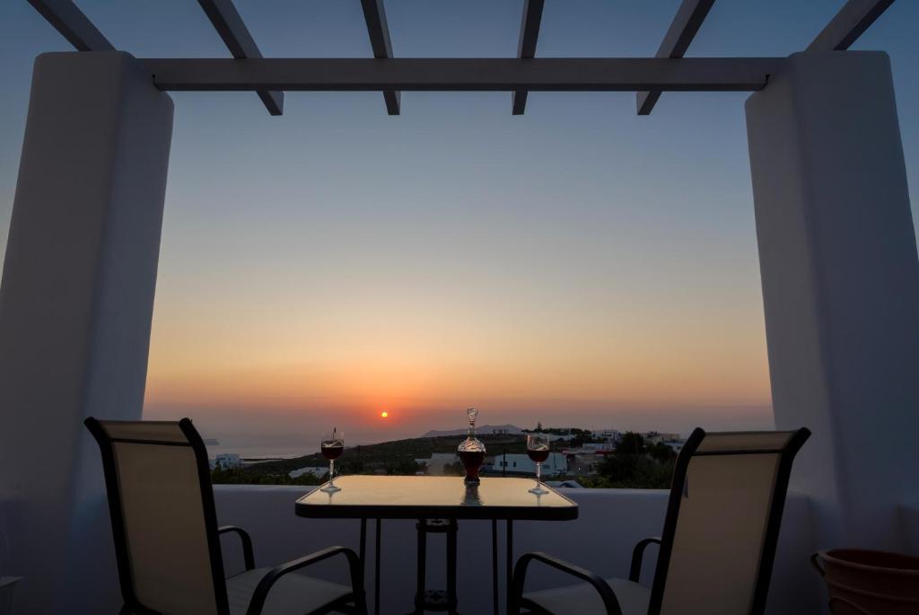 a table and chairs with a view of the sunset at Sun View Villas in Pyrgos