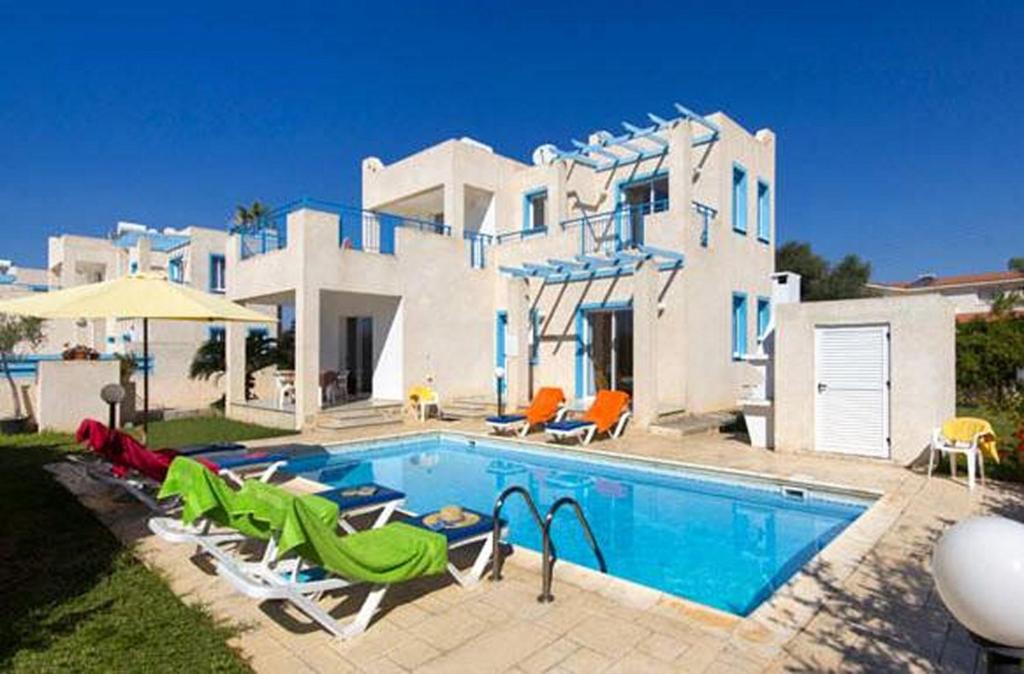 a large house with a swimming pool in front of it at Philippos Paphos villas - villa 3 in Paphos City