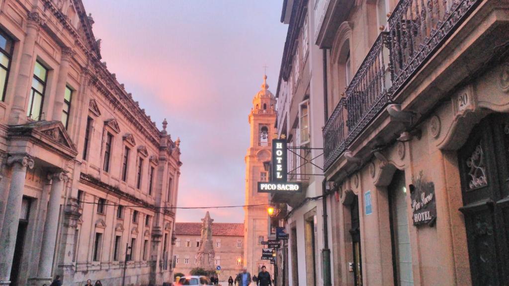 una calle de la ciudad con una torre de reloj en la distancia en PICO SACRO II HOTEL Santiago de Compostela en Santiago de Compostela