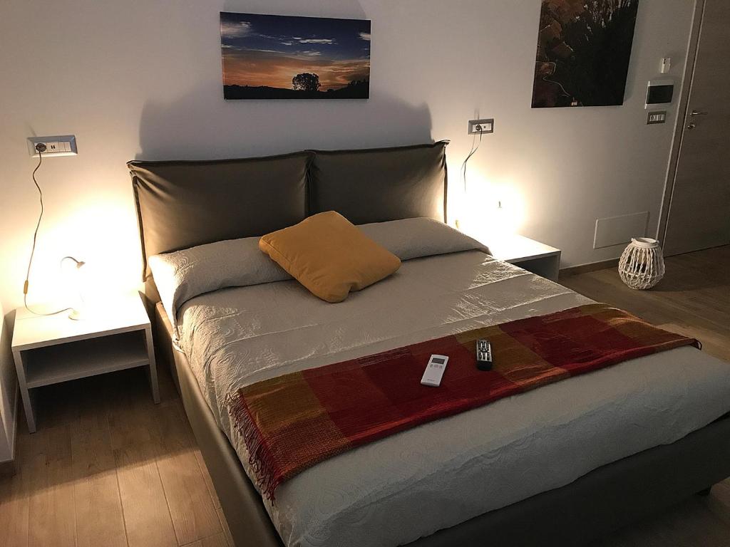 阿爾巴的住宿－Casa Soave B&B，卧室内的一张床位,配有两张桌子和两盏灯