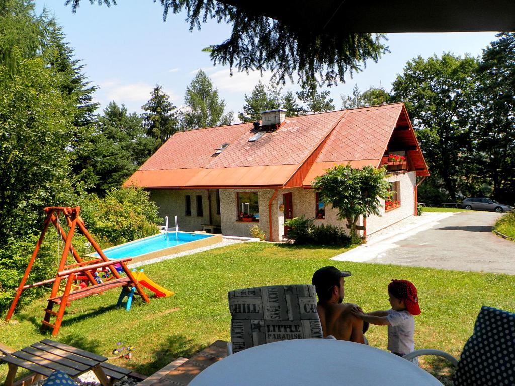 two children playing in the yard of a house at Penzion Bor in Náchod