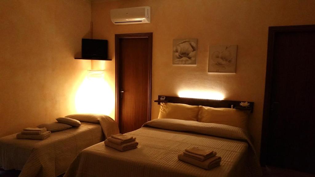 Habitación de hotel con 2 camas y toallas. en Civita Nova, en Bagnoregio