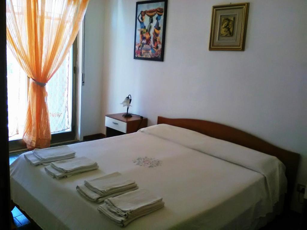 Un dormitorio con una cama con toallas y una ventana. en Appartamento Ginepri, en Lamezia Terme