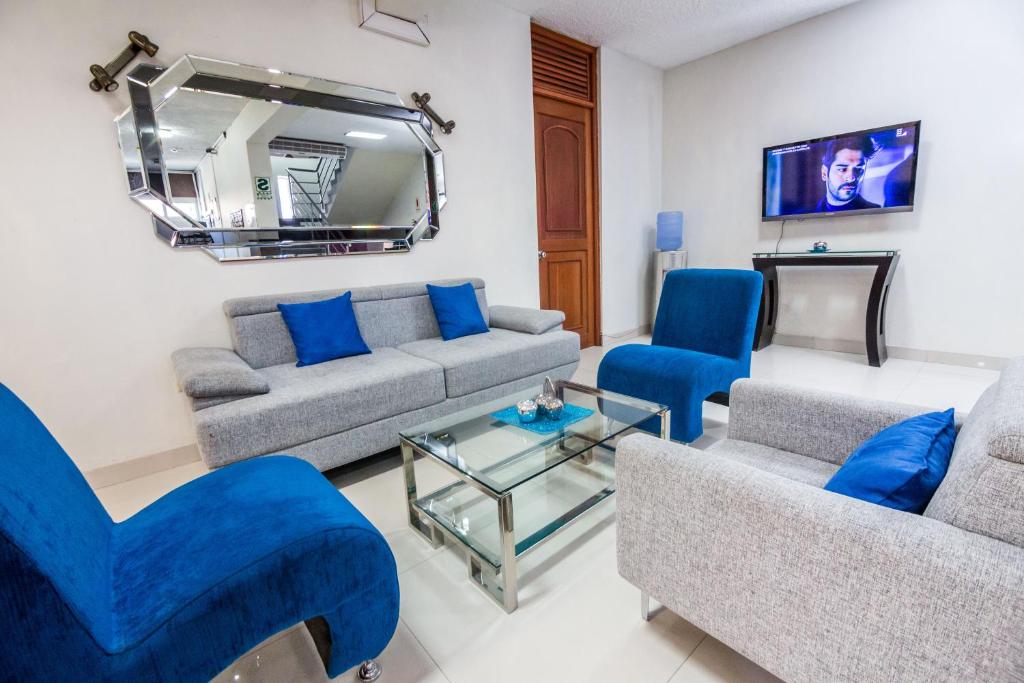 un soggiorno con mobili blu e specchio di Hotel El Sol a Piura