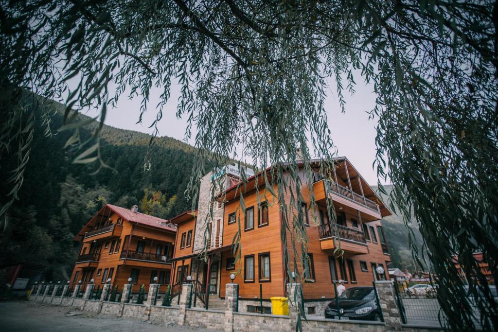 a large wooden building with cars parked in front of it at Turkuaz Apart in Uzungöl