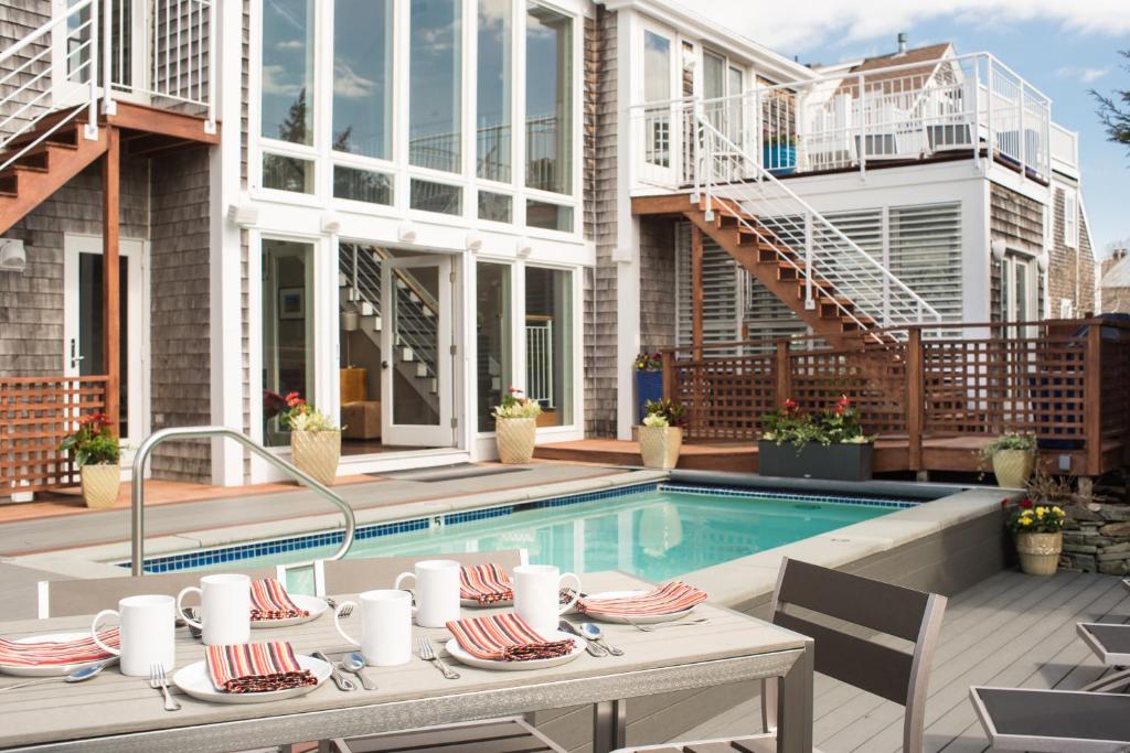 um pátio com uma mesa e uma piscina em 8 Dyer Hotel em Provincetown