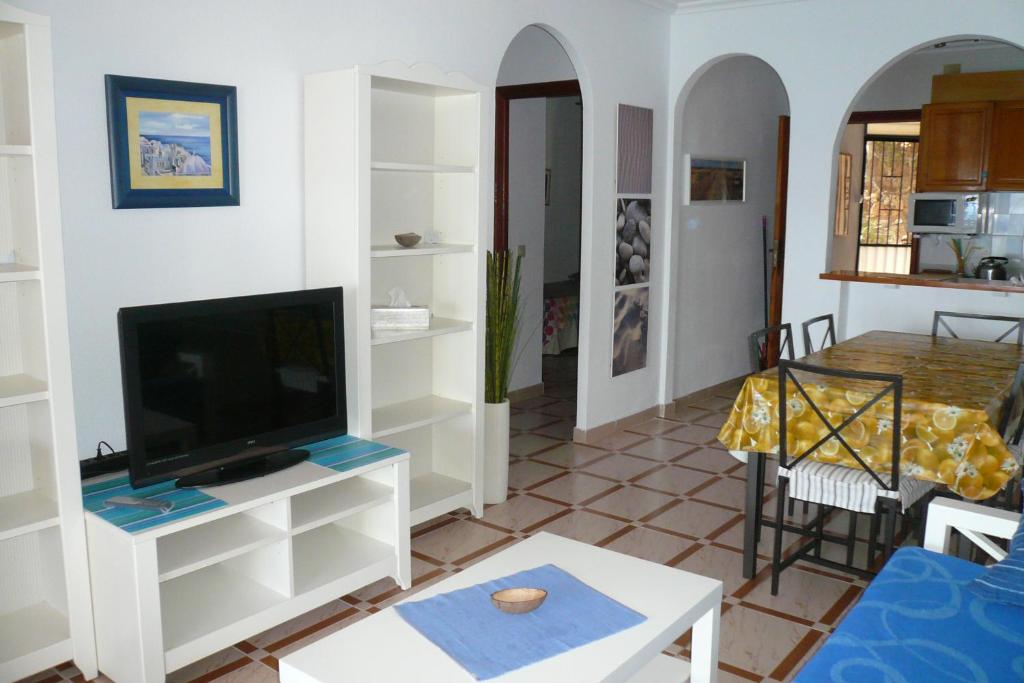 salon z telewizorem i stołem w obiekcie MEDITERRANEAN BEACH APARTMENT 180º SEA & ISLAND VIEWS w mieście Santa Pola