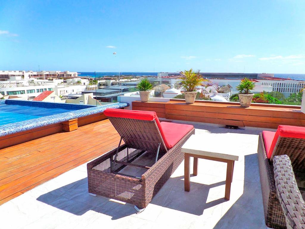 patio z 2 krzesłami i stołem na dachu w obiekcie Skyline 204 w mieście Playa del Carmen