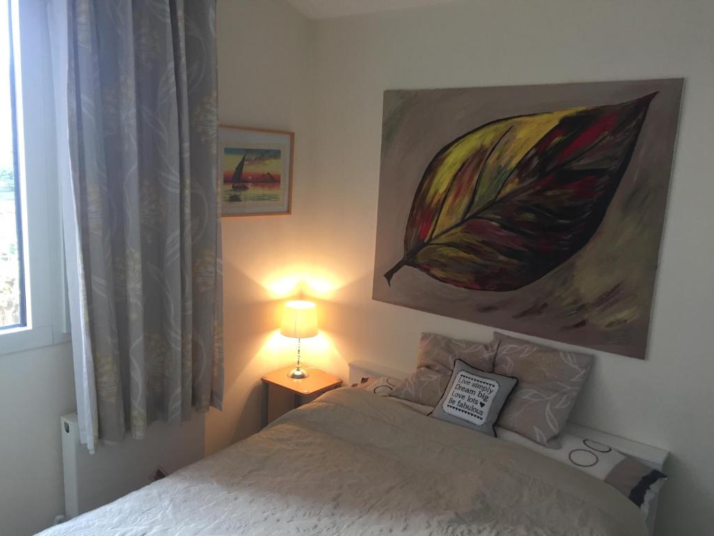 a bedroom with a bed and a painting on the wall at Eco House in Shenley Church End