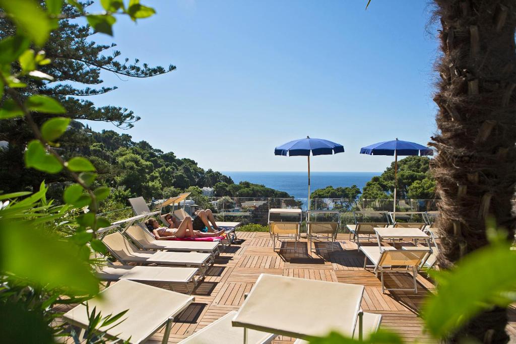 uma fila de espreguiçadeiras e guarda-sóis numa praia em Hotel La Floridiana em Capri