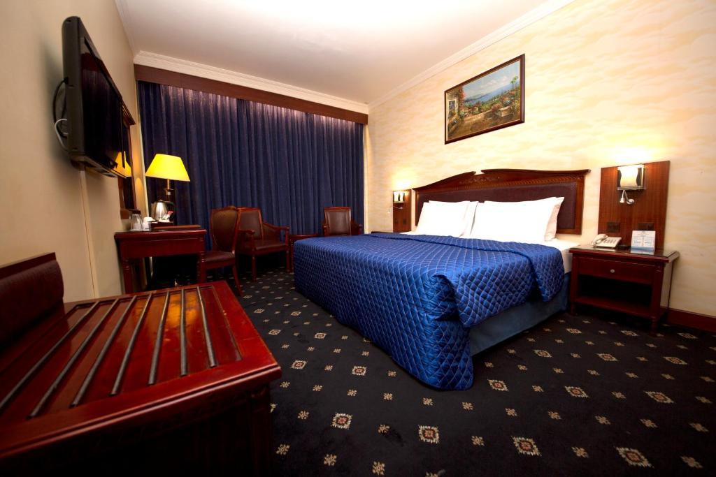 a hotel room with a bed and a television at Mount Royal Hotel in Dubai