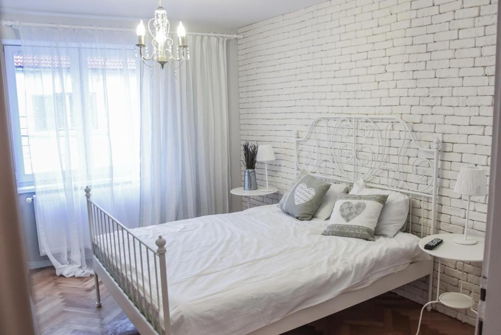 シビウにあるCasa Gloria Sibiuの白レンガの壁、ベッド付きの白いベッドルームが備わります。