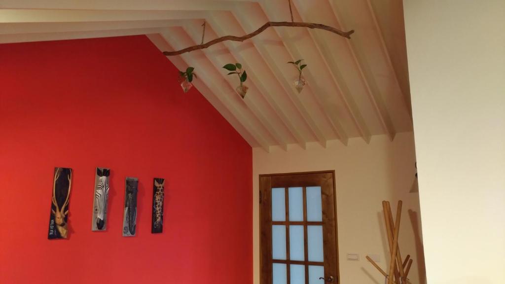 a room with a red wall with skis on it at Celine&#39;s B&amp;B in Fenglin