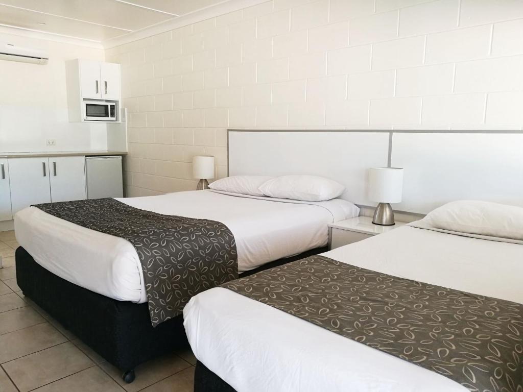 a hotel room with two beds and a microwave at Augathella Motel & Caravan Park in Augathella
