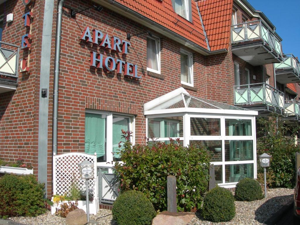 a large red brick building with a star hotel sign on it at Apart Hotel Norden in Norden