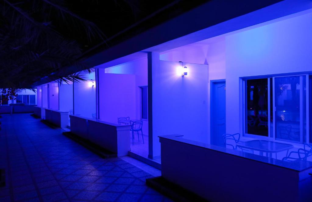 a row of sinks in a room with purple lights at Fujairah Hotel & Resort in Fujairah