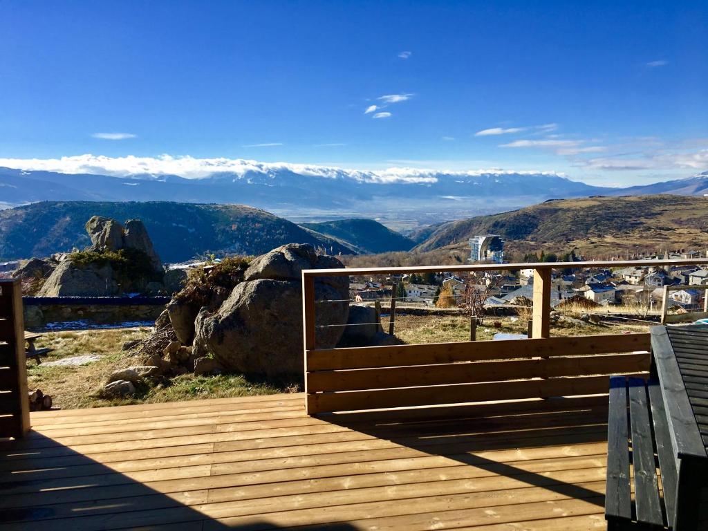une terrasse en bois avec vue sur les montagnes dans l'établissement Résidence Le Clos Saint-Savin, à Font-Romeu-Odeillo-Via
