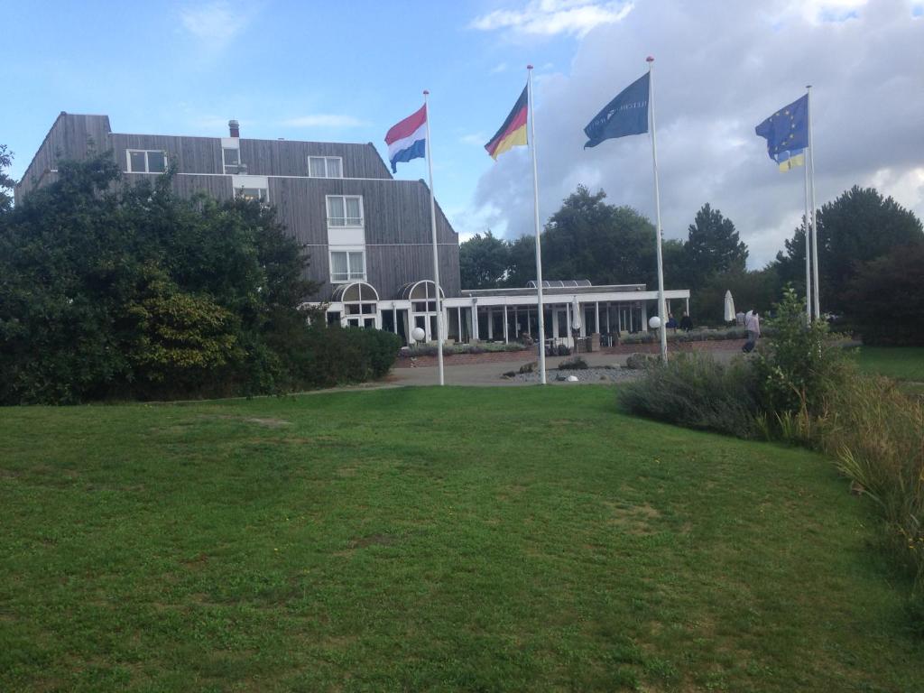 um grupo de bandeiras em frente a um edifício em Kaapshoff 32 em Hollum