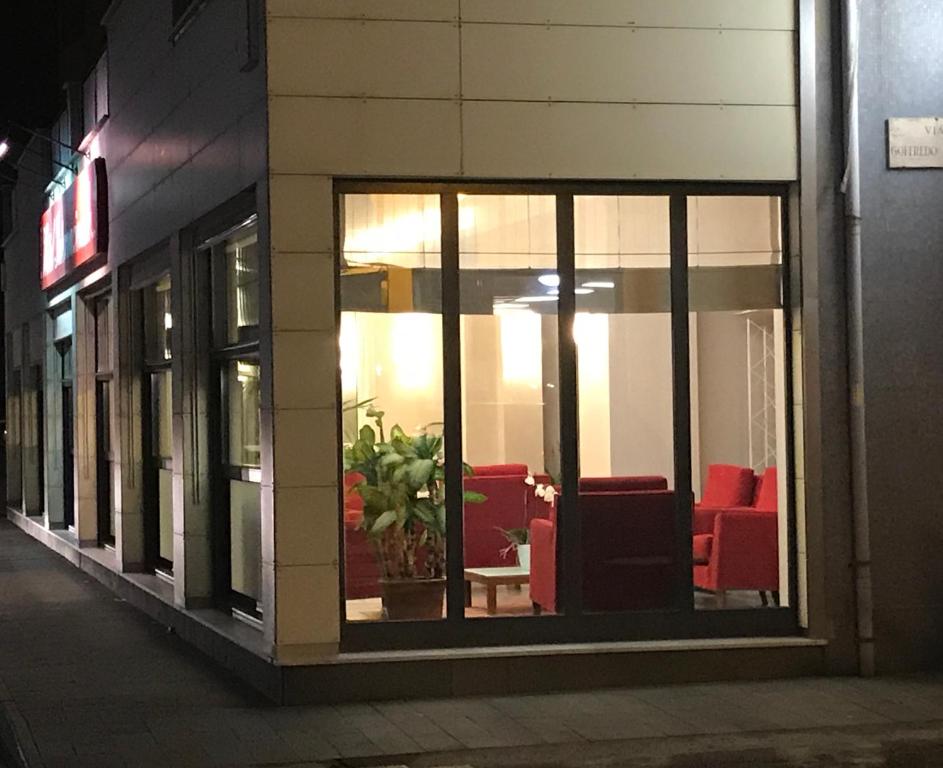 uma vitrine com cadeiras vermelhas dentro em Hotel Internazionale em Finale Ligure