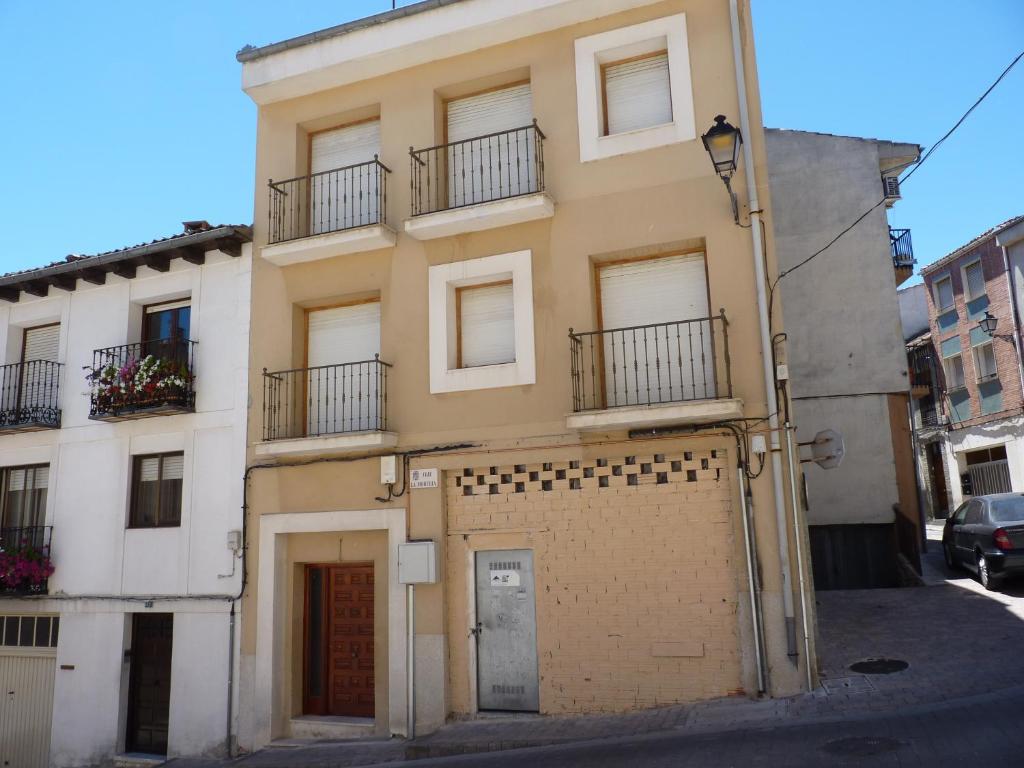 un edificio amarillo con 2 balcones en una calle en LA MORERIA, alojamiento turístico, en Cuéllar