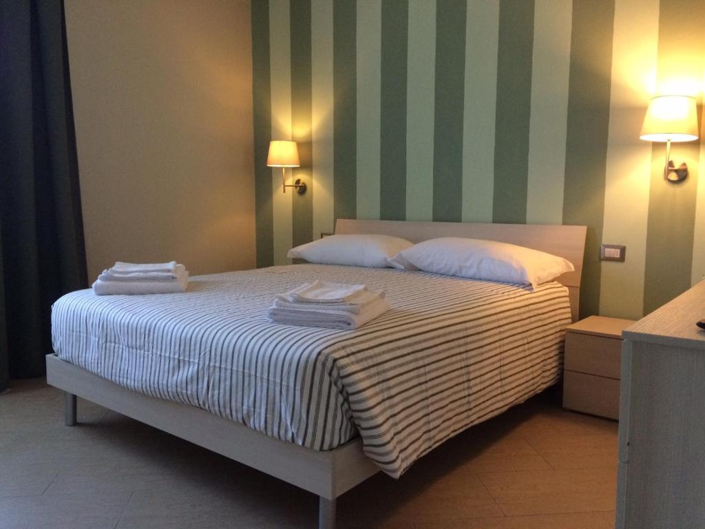 een slaapkamer met een bed met handdoeken erop bij Le terme a due passi in Rapolano Terme