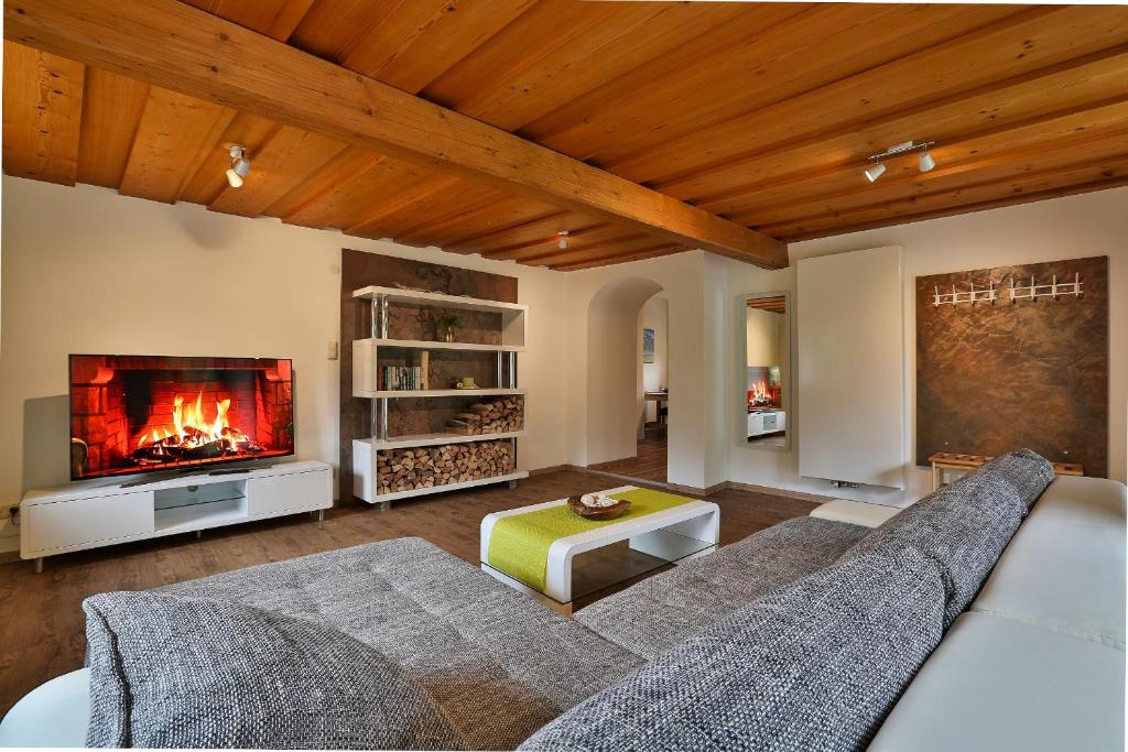 sala de estar con sofá y chimenea en Ferienwohnung Holzenlehen en Ramsau