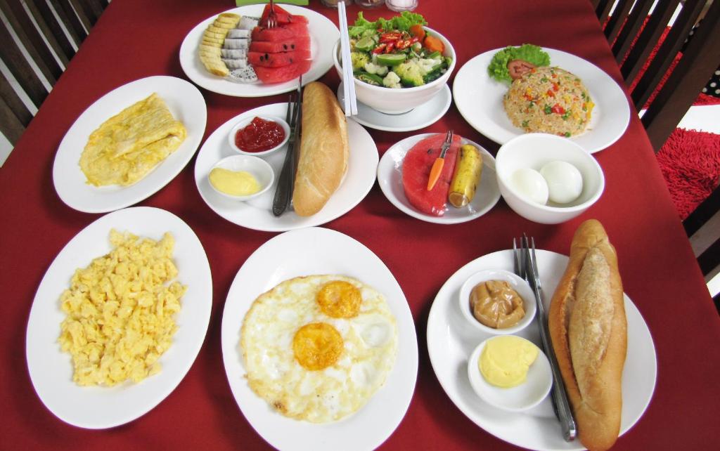 a red table with plates of food on it at Blossoming Romduol Boutique in Siem Reap