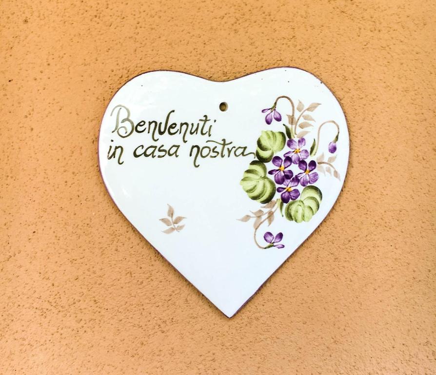 ein herzförmiges Schild mit Blumen an der Wand in der Unterkunft Citta Giardino B&B in Rom
