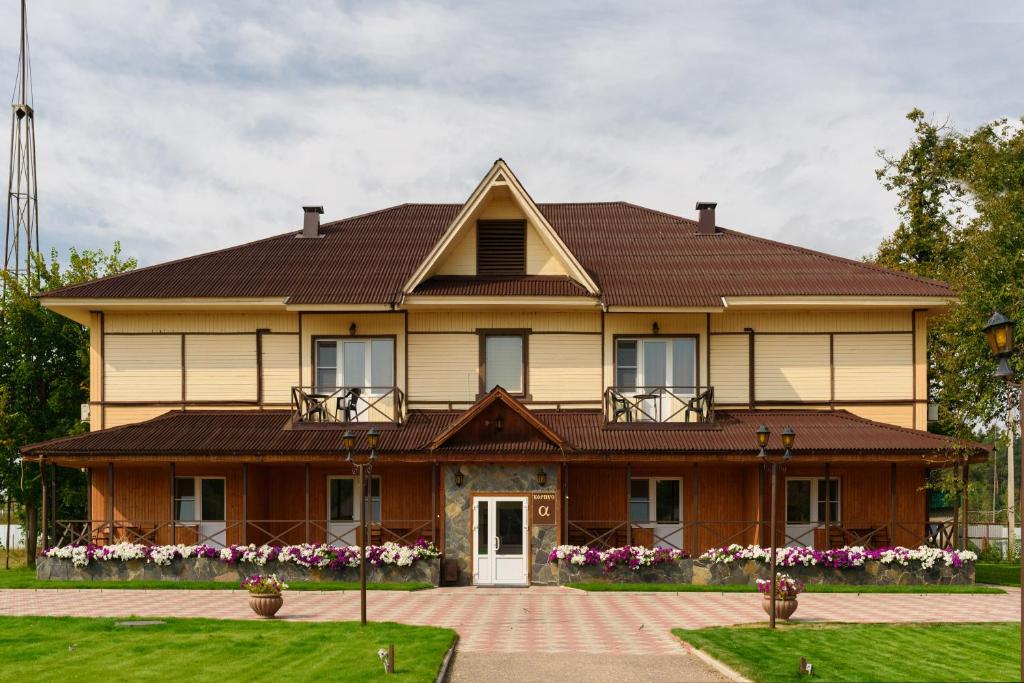 een groot huis met een bruin dak bij Hotel Complex Park hotel D-grad in Dimitrovgrad