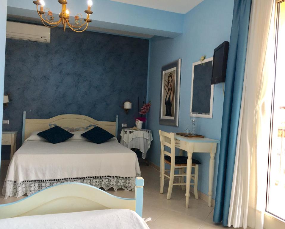 a bedroom with a bed and a table and a desk at Hotel Scilla in Scilla