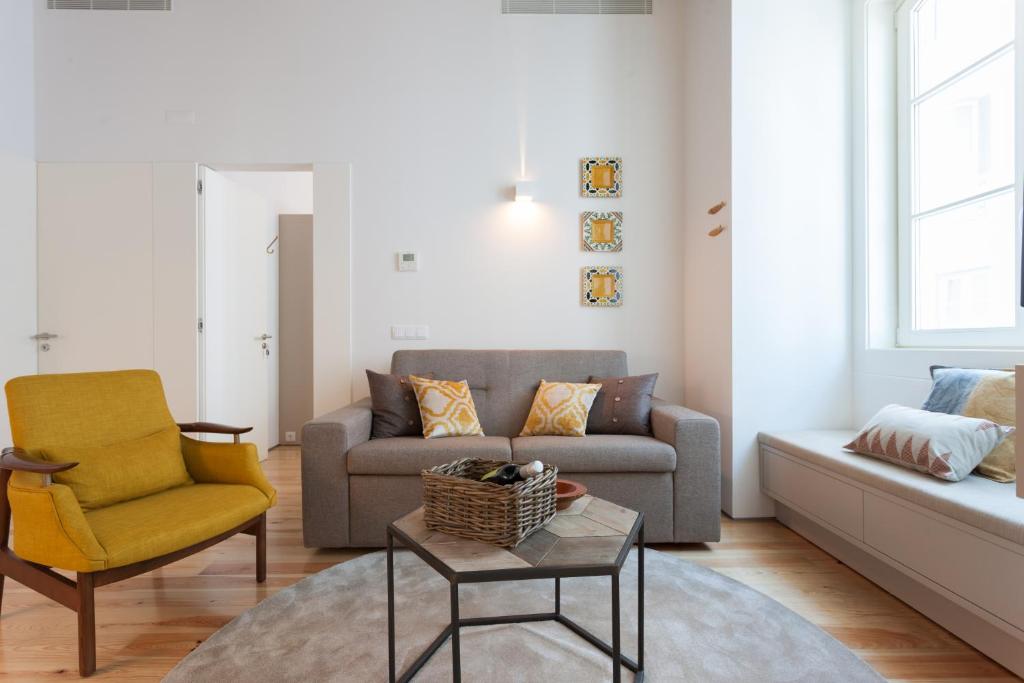 uma sala de estar com um sofá e uma cadeira em FLH Alecrim Modern Flat em Lisboa