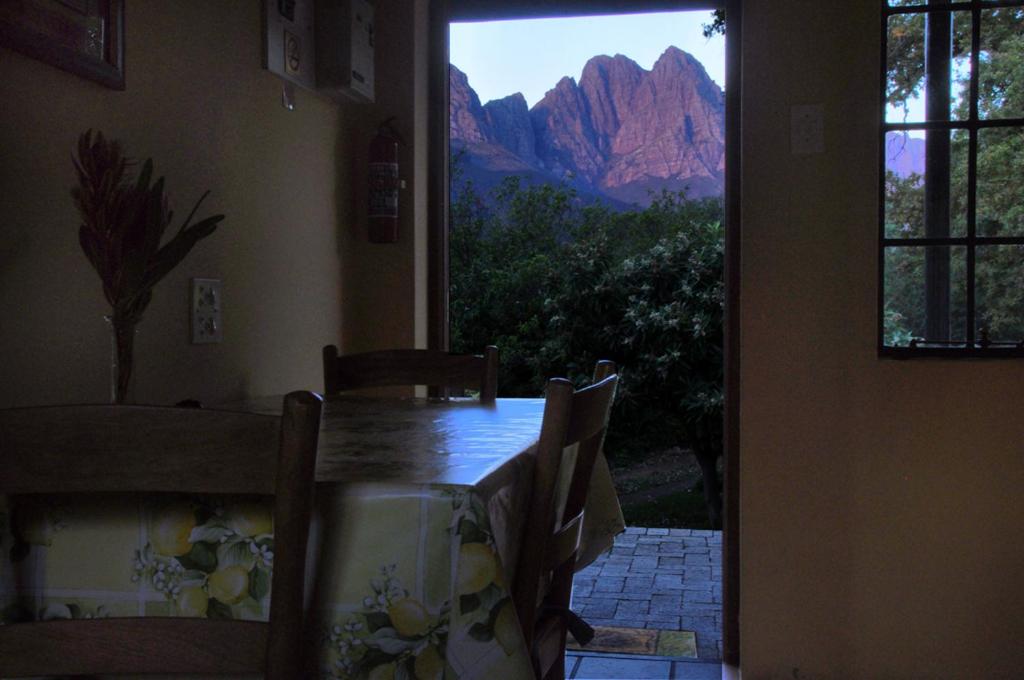 a dining room table with a view of a mountain at Kierie Kwaak Self Catering in Stellenbosch