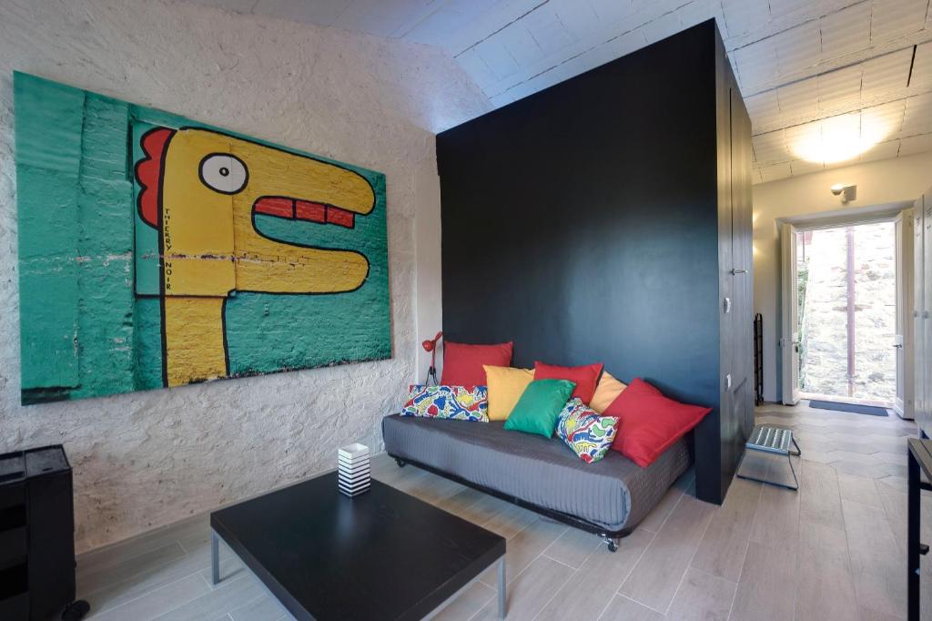 a living room with a couch and a painting on the wall at THE VIEW a Pop Style Apartment in Maremma, Cana in Cana