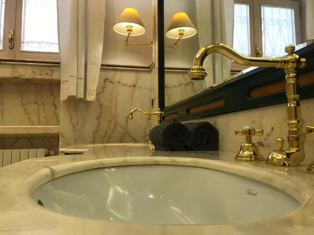 łazienka z umywalką i kranem w obiekcie Yucca Camere & Suite w mieście Trani