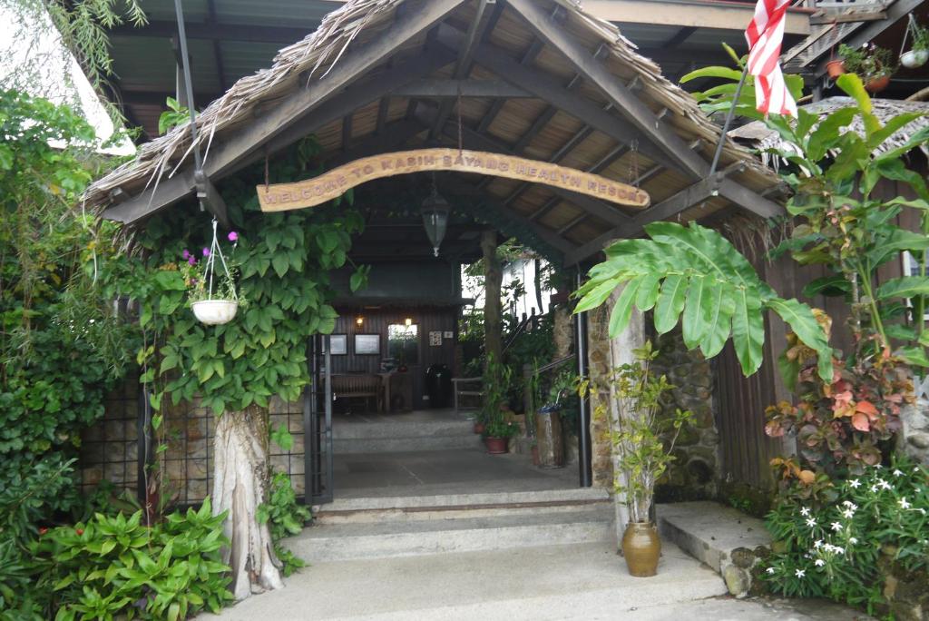 亞庇的住宿－Kasih Sayang Hill Resort，一座植物繁多的建筑的入口