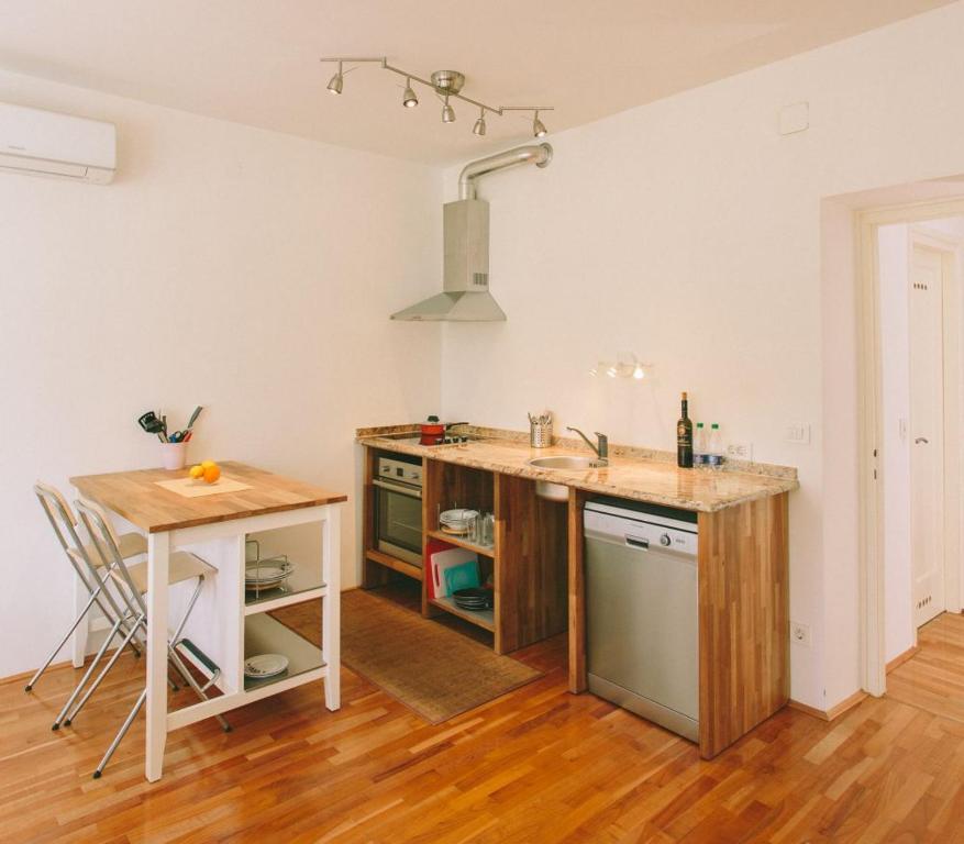 a kitchen with a counter and a sink and a table at Apartment Savska in Zagreb
