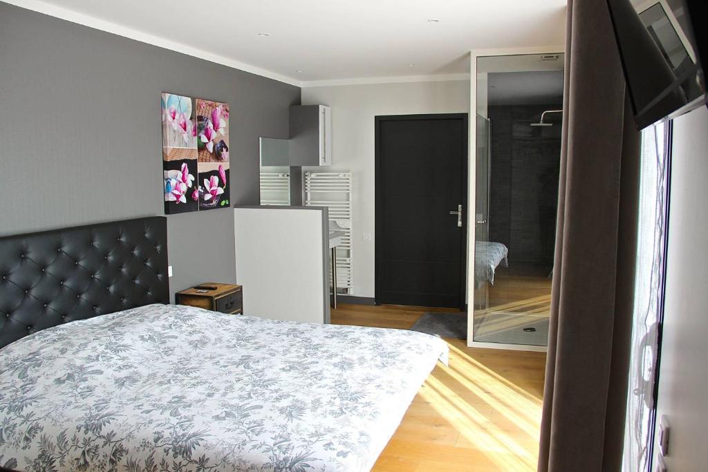 ein Schlafzimmer mit einem Bett und einem großen Spiegel in der Unterkunft Chambres d'hotes ASAM in Lherm