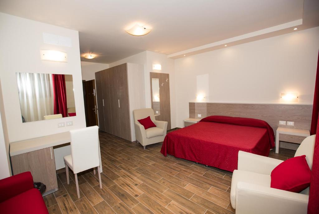 アルチドッソにあるB&b Amiataのベッドルーム1室(赤いベッド1台、テーブル、椅子付)