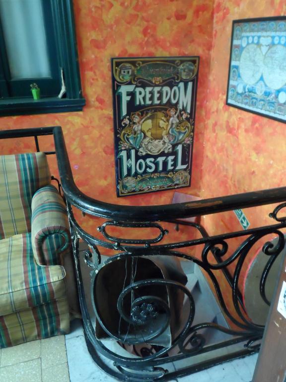 a metal bench against a wall with a sign on it at Freedom Hostel in Rosario