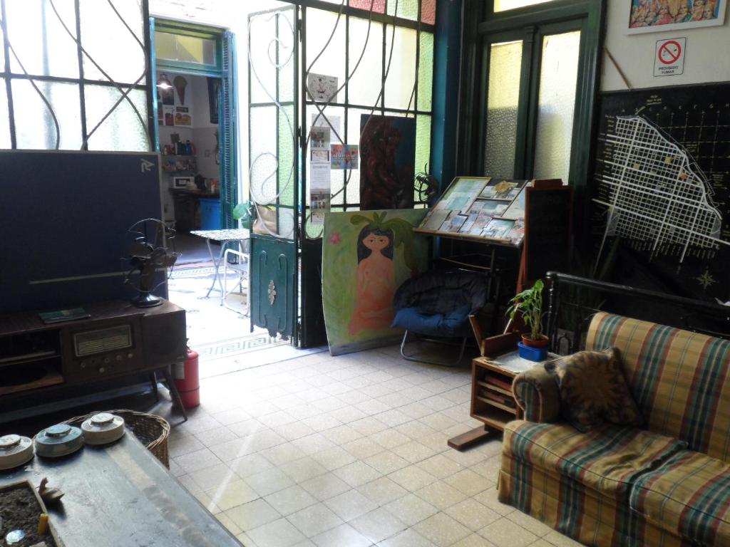 uma sala de estar com um sofá e uma televisão em Freedom Hostel em Rosário