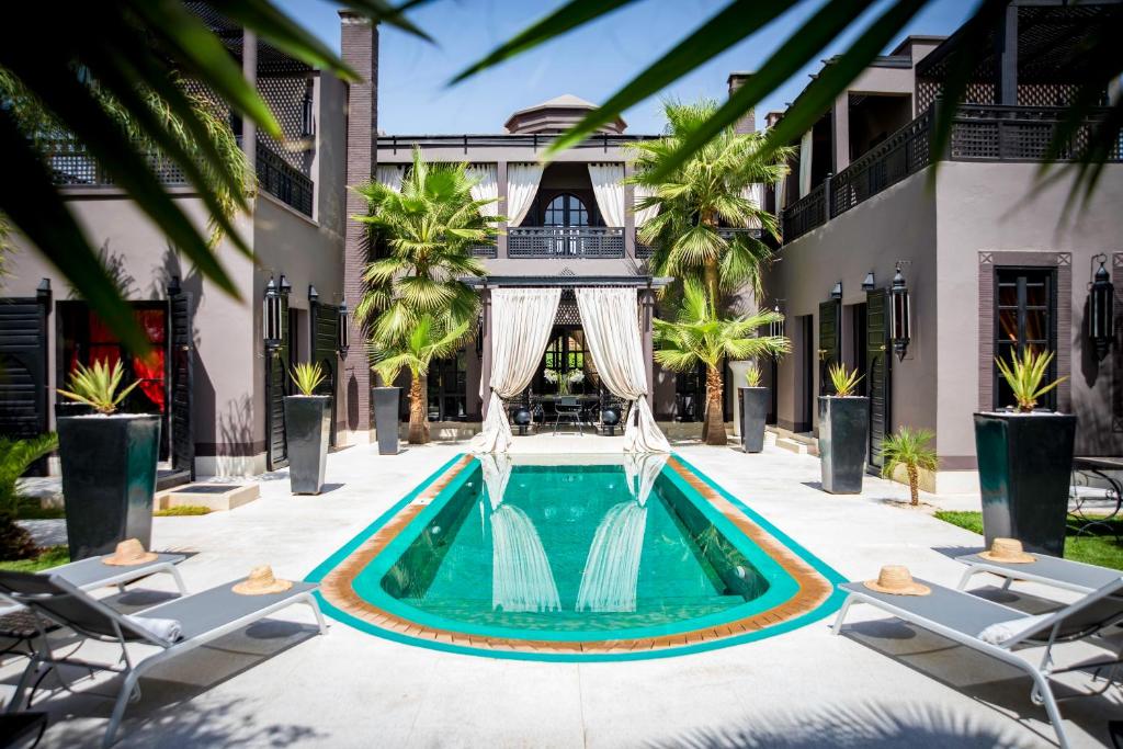 a swimming pool with a fountain in the middle of a building at Villa Mano in Marrakesh