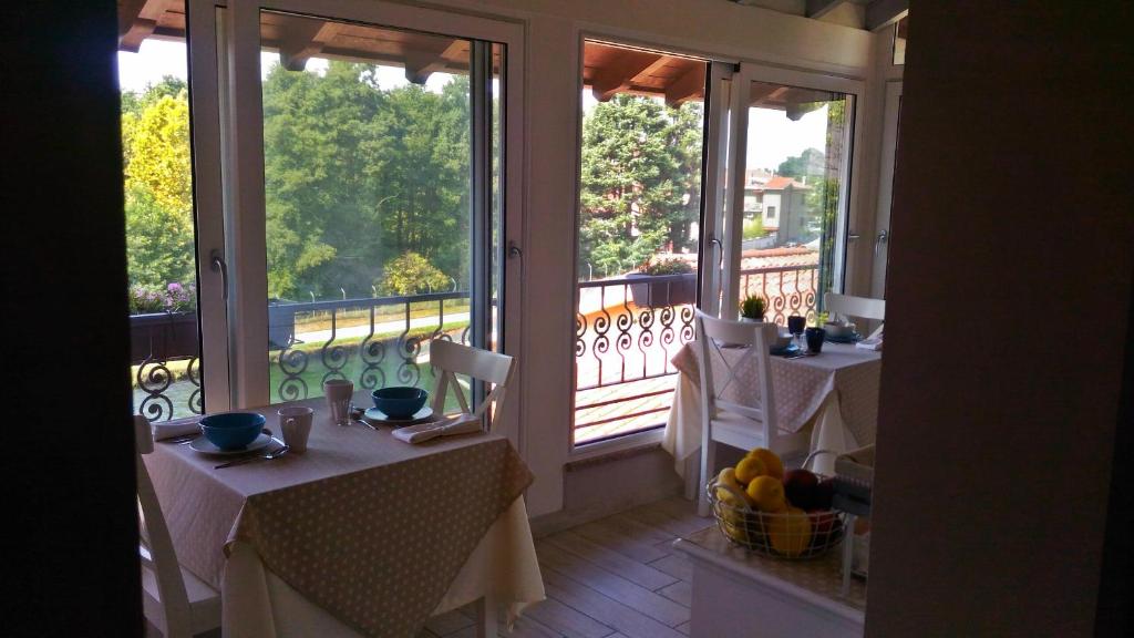 Zimmer mit 2 Tischen und einem Balkon mit Fenstern in der Unterkunft La Terrazza sul Naviglio B&B in Bernate Ticino