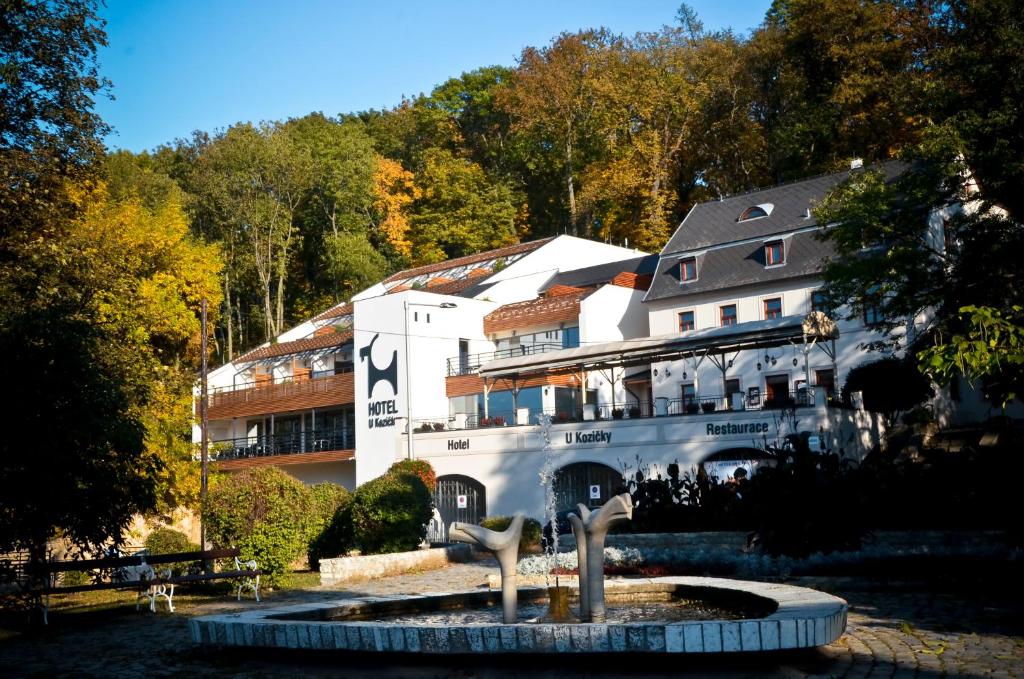 ein großes weißes Gebäude mit einem Brunnen davor in der Unterkunft Hotel U Kozicky in Teplice