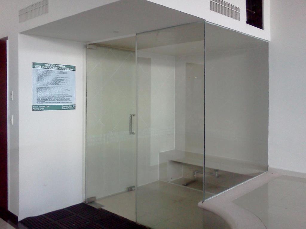 A glass-walled shower enclosure stands in the indoor pool and fitness area.