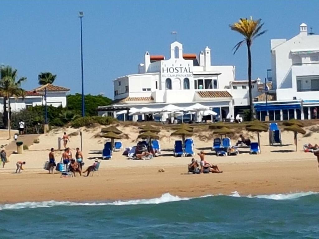 un grupo de personas en una playa con un hotel en El Campanario, en Chiclana de la Frontera