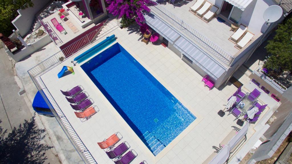 een uitzicht op een zwembad met ligstoelen en sidx sidx bij Resort due gatte Pinky Trogir in Seget Vranjica