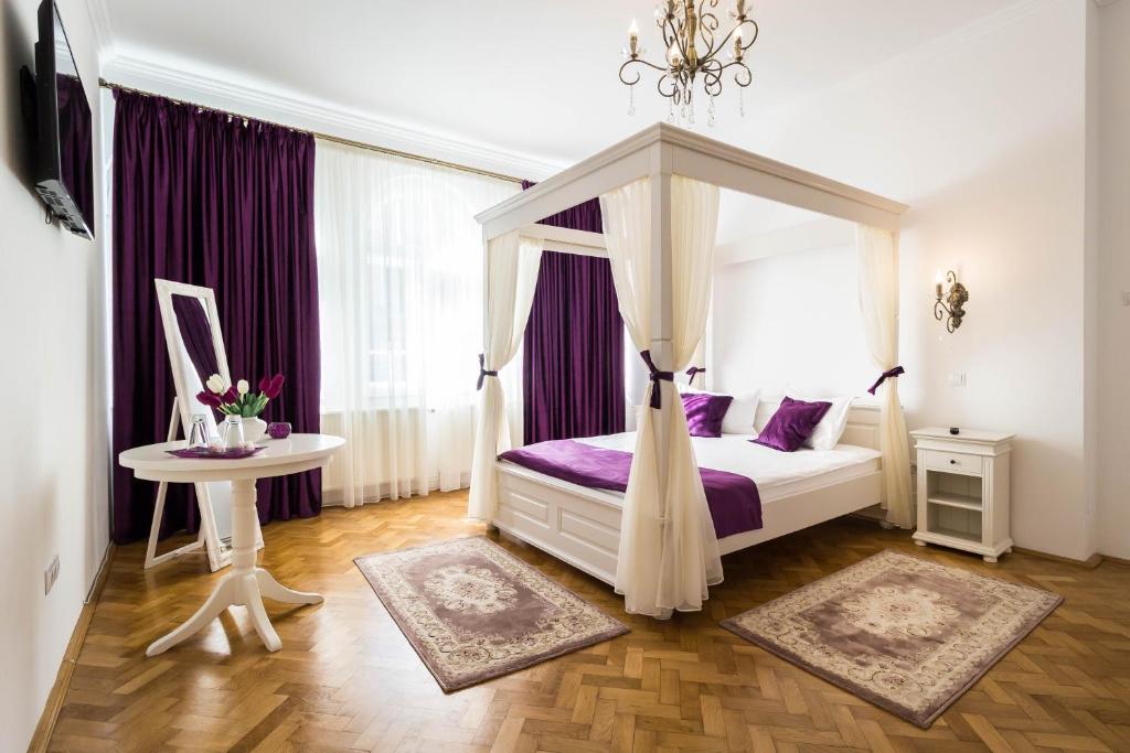 1 dormitorio con cama con dosel y mesa en Vila Mărioara, en Sibiu